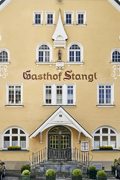 Ein großes gelbes Hotel in Vaterstetten mit symmetrischen Fenstern.